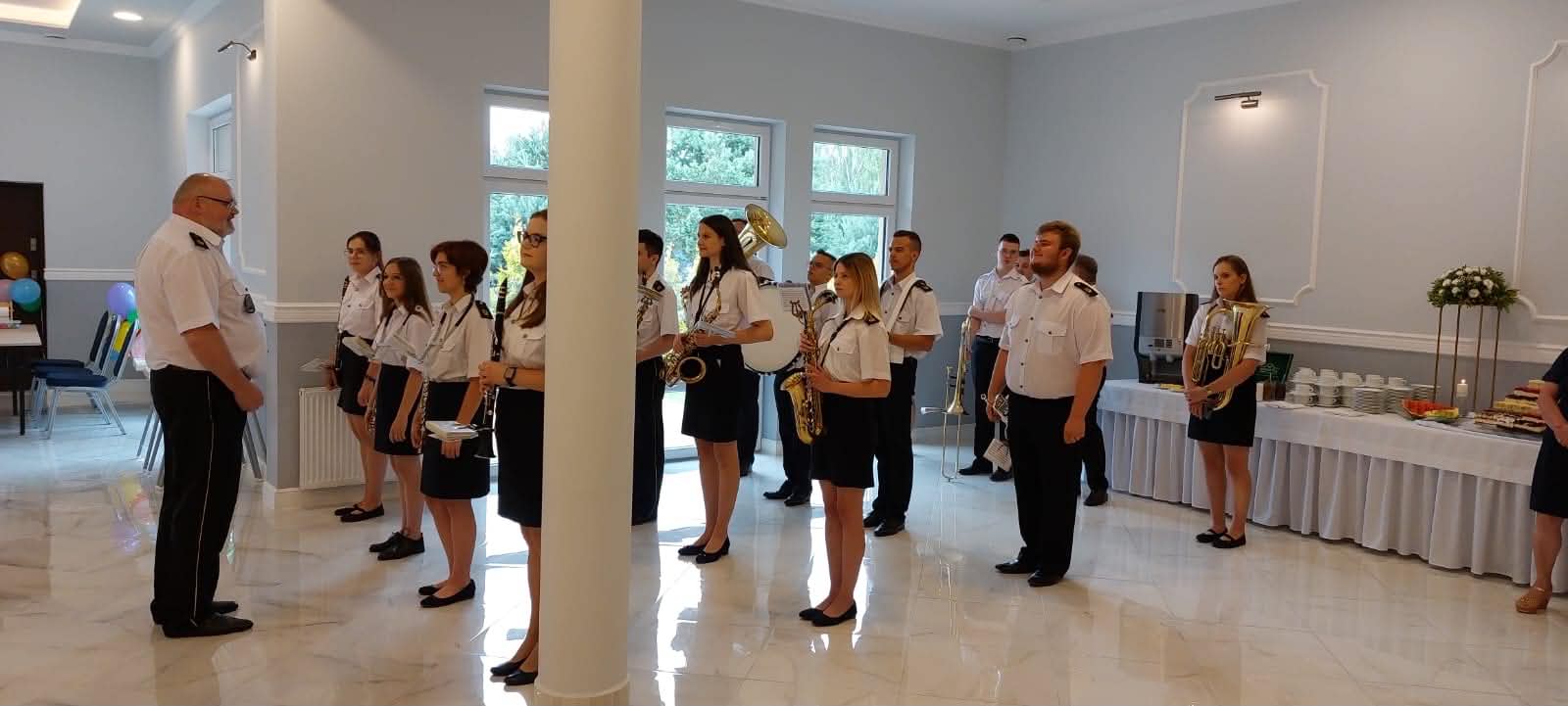 Sala Weselno-Bankietowa Glamour Chroboty - występ orkiestry dętej w jasnej sali głównej, oprawa muzyczna uroczystości z bufetem deserowym w tle