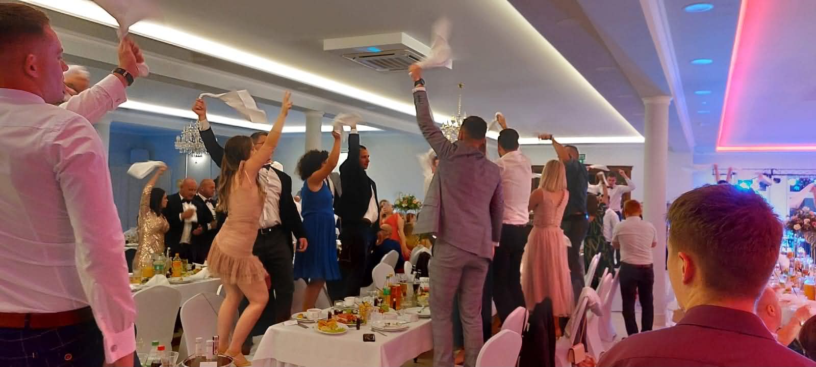Sala Weselna Glamour Chroboty - zabawa weselna na parkiecie, goście tańczą z chustami uniesionymi w górze, nastrojowe oświetlenie LED w odcieniach różu i błękitu