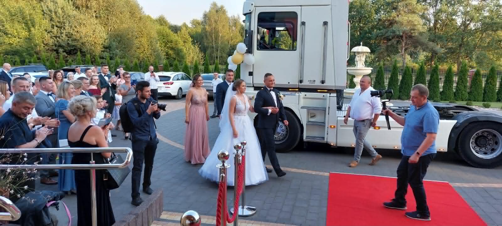 Sala Weselna Glamour Chroboty - nietypowy przyjazd pary młodej ciężarówką, czerwony dywan, fontanna i goście witający nowożeńców